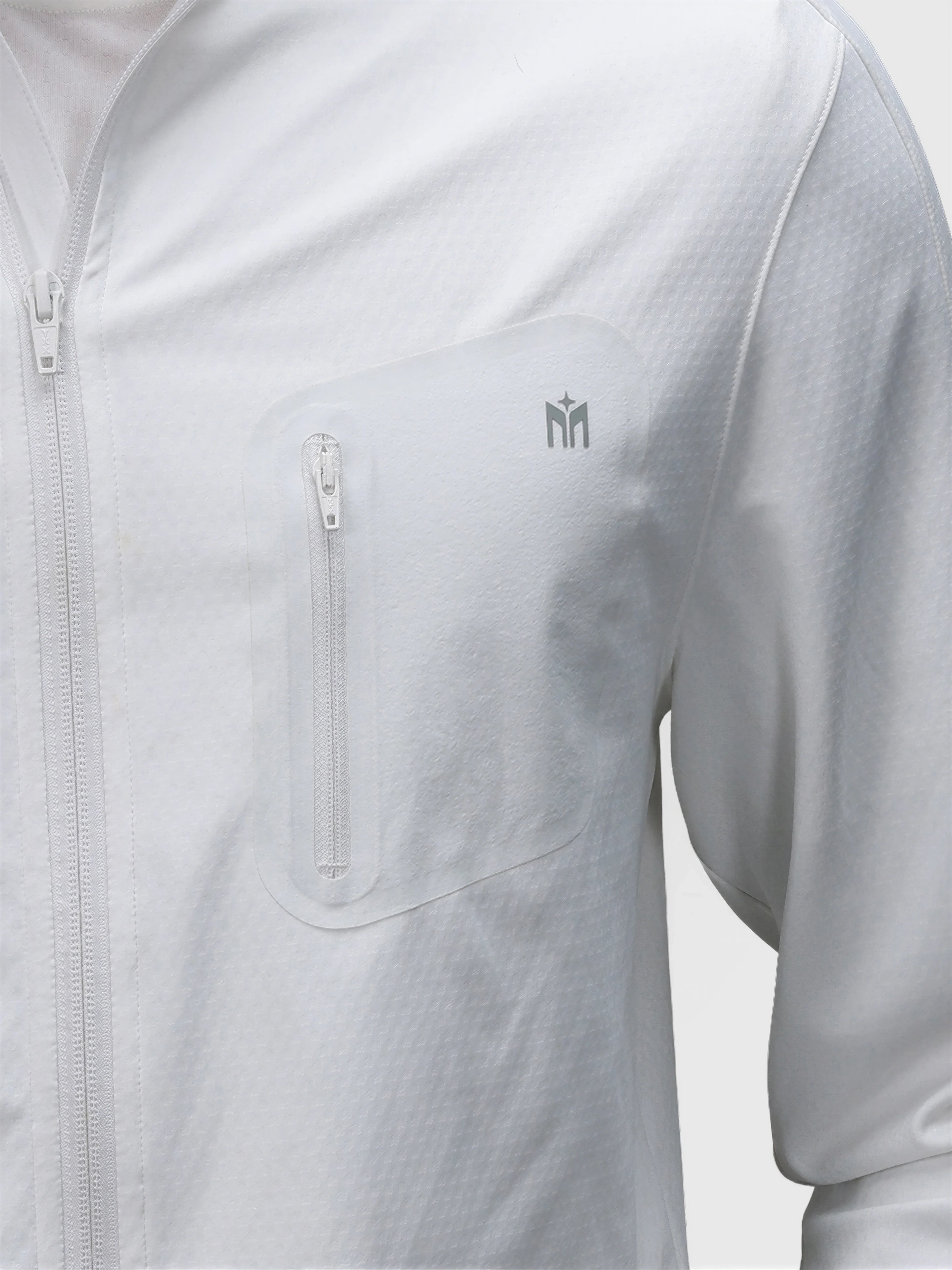 Close-up of white Echelon Jacket by MUEV featuring zippered chest pocket in pickleball clothing
