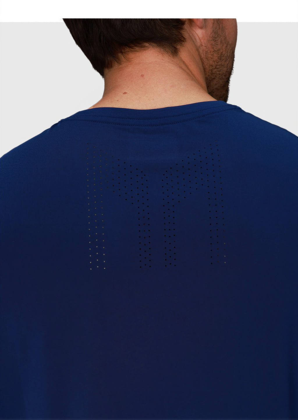 close-up back view of man wearing navy Chevron Tee by MUEV designed for padel and pickleball clothing