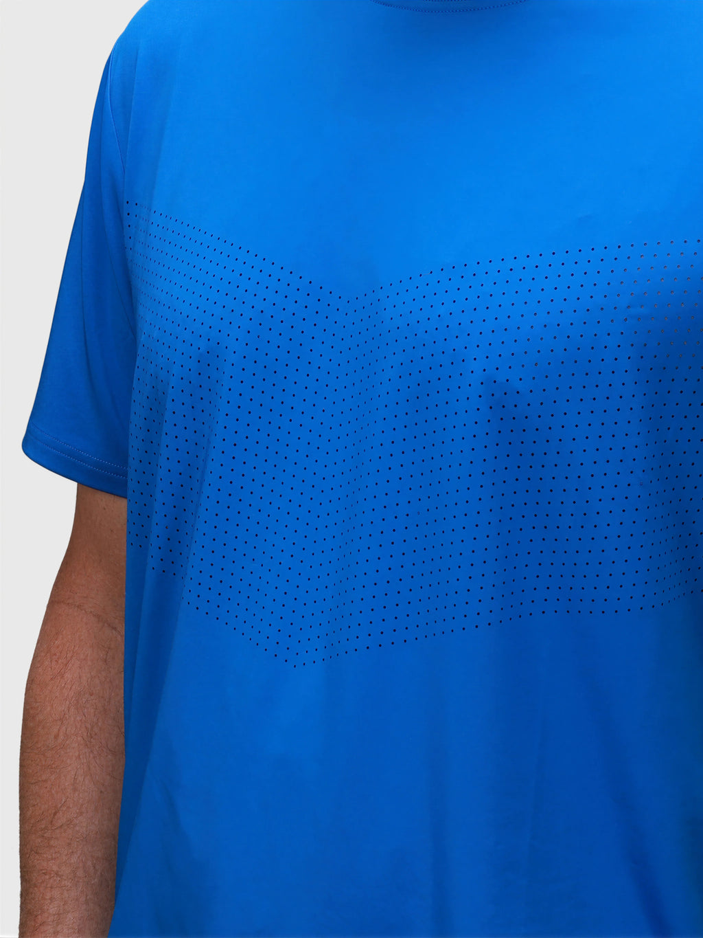 Close-up of a bright blue Chevron Tee with subtle perforated design in padel clothing by MUEV
