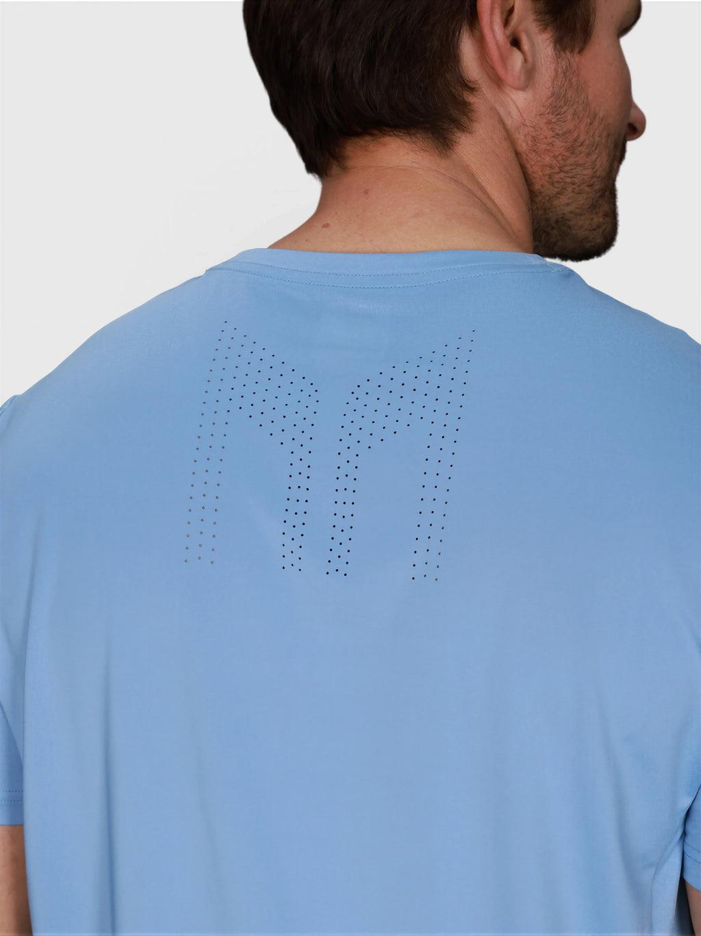 close-up back view of man wearing Cloud Blue Chevron Tee by MUEV designed for padel and pickleball apparel